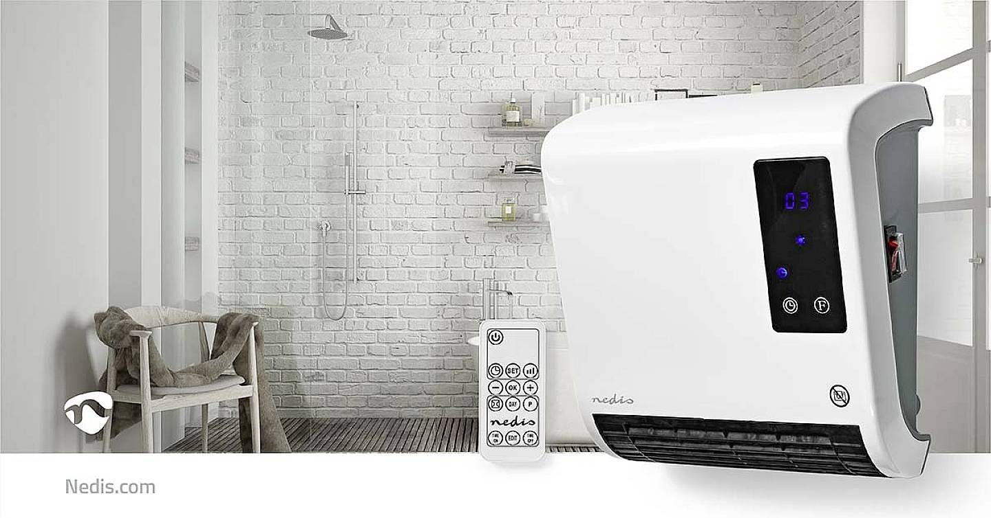 Een witte wandverwarming en afstandsbediening in de badkamer. Op de achtergrond een witte bakstenen muur met een douche.