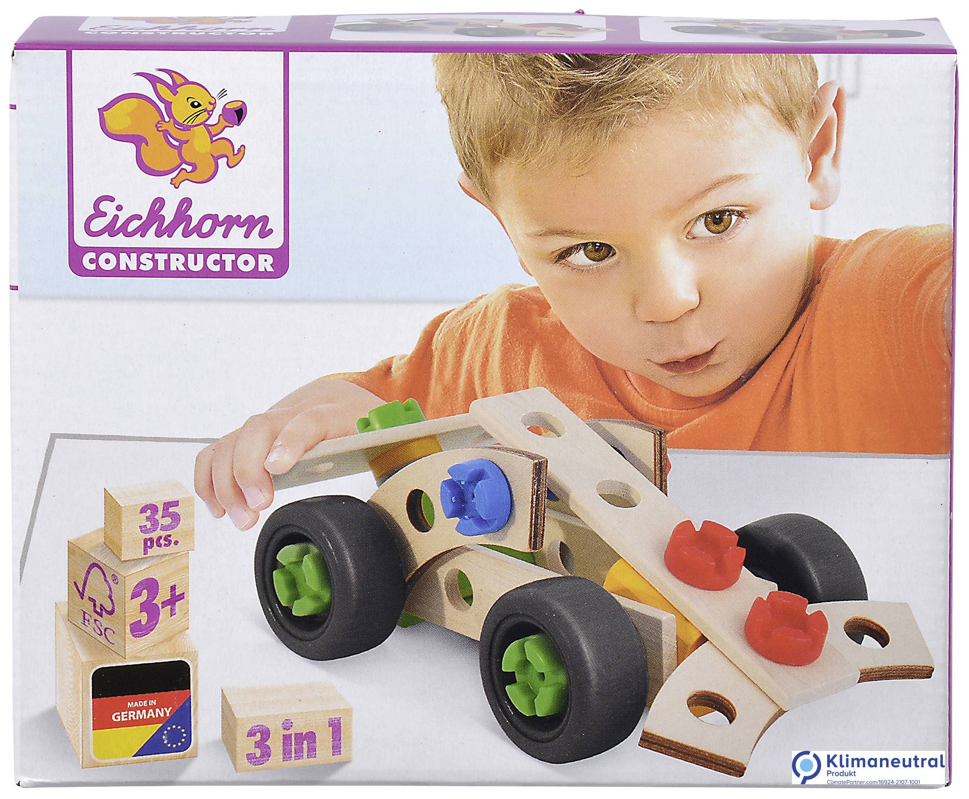 Kleinkind speelt met een houten constructieset van een eekhoorn. De set bevat gekleurde bouwstenen en wielen. De verpakking toont '3-in-1' en 'Made in Germany'.