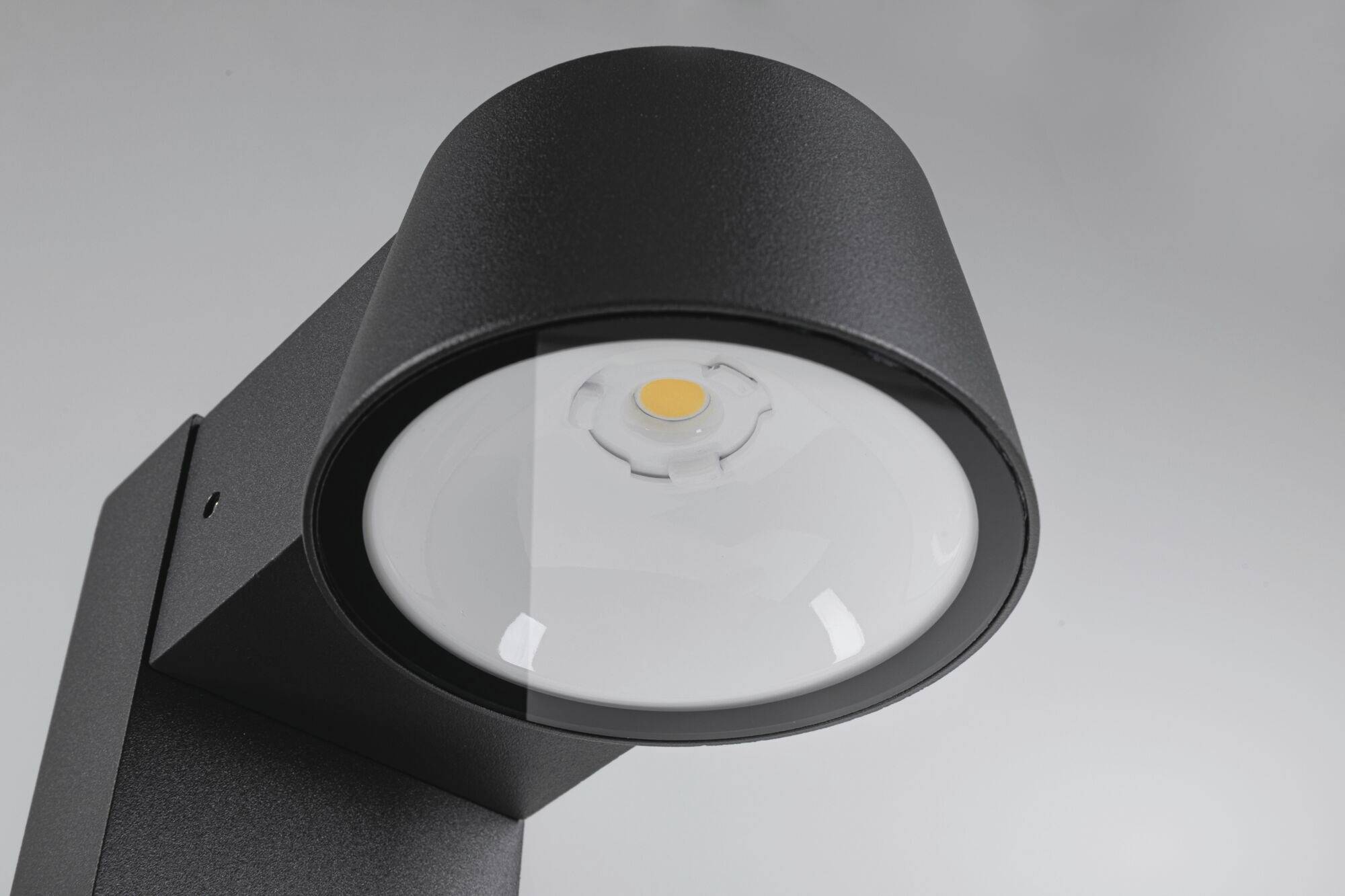 Zwart LED-buitenlicht met een ronde lampkop en heldere afdekking, schijnt naar beneden. Modern design voor buitenruimtes.