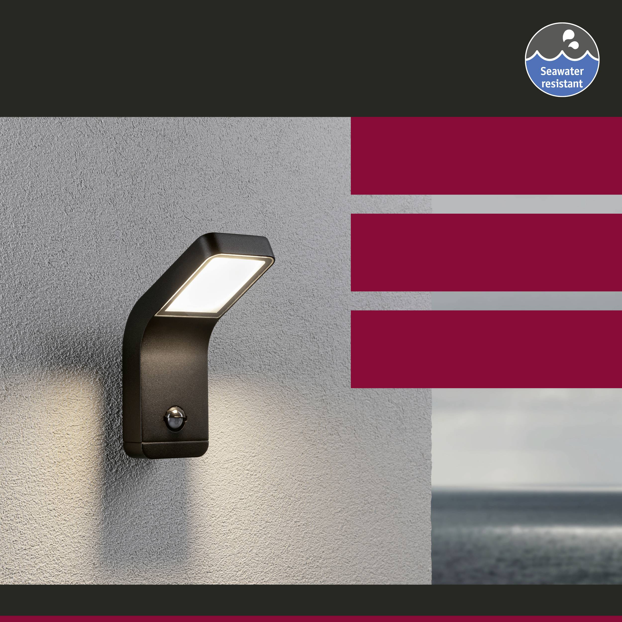 Buitenwandlamp aan een muur, verlicht, met cilindrische vorm. Label rechtsboven toont 'Zeewaterbestendig'. Zee op de achtergrond.