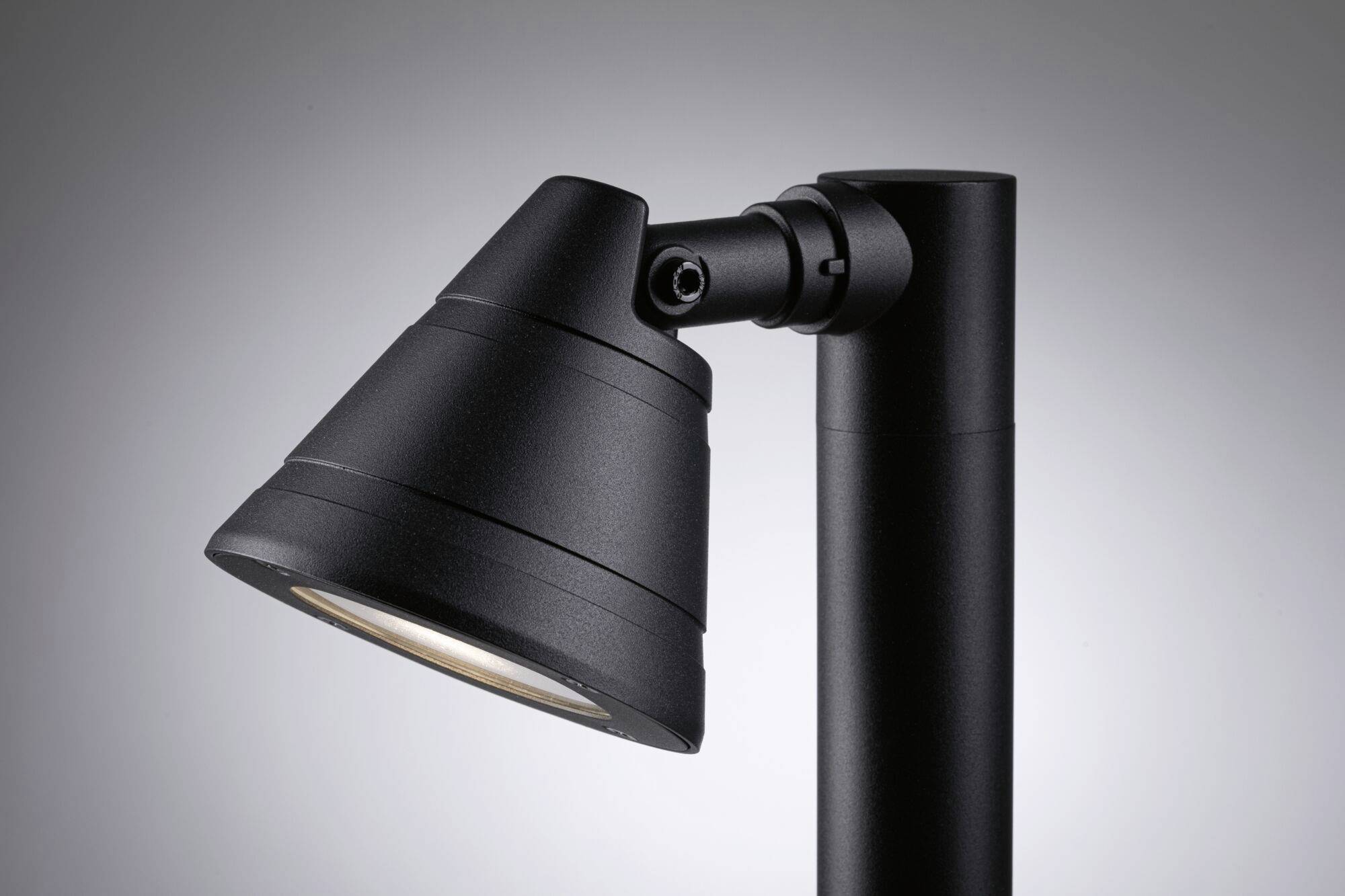 Een zwarte, moderne plafondlamp met een conische lampenkap, gericht tegen een grijze achtergrond.