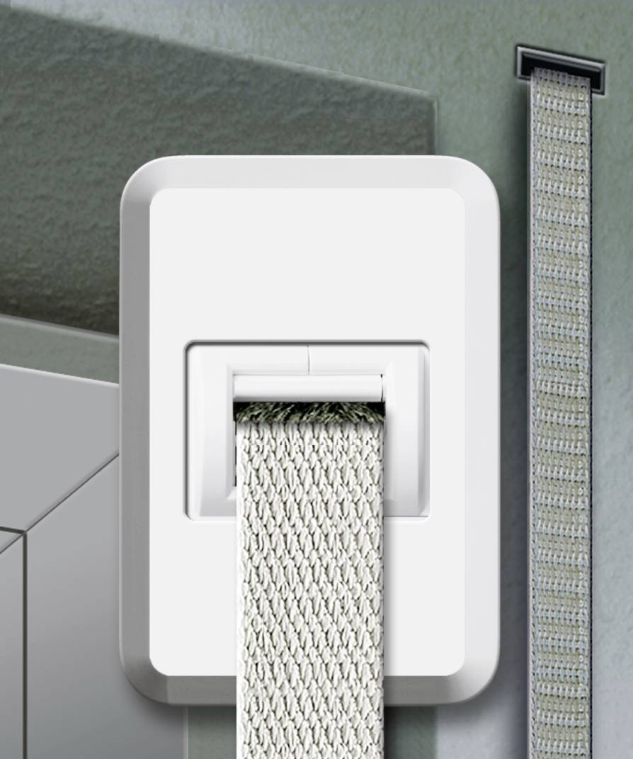 Een witte gordijnrolautomaat met een beige rolluikband is aan een muur bevestigd. Het band loopt verticaal omhoog naar het raam.