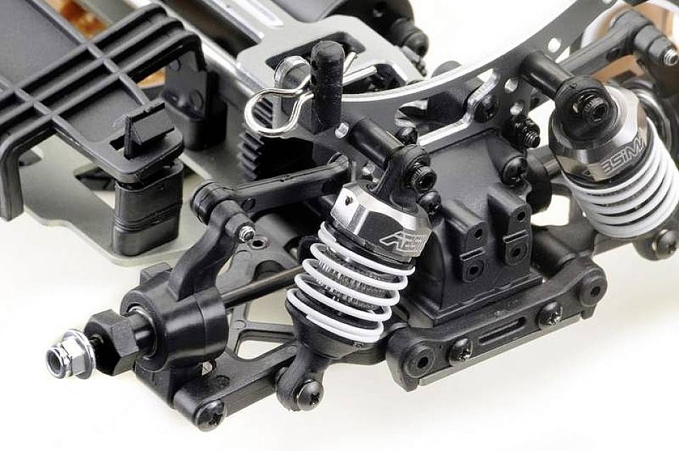 Close-up van een afstandsbediend voertuigchassis met schokdempers, vering en metalen onderdelen die technische details onthullen.