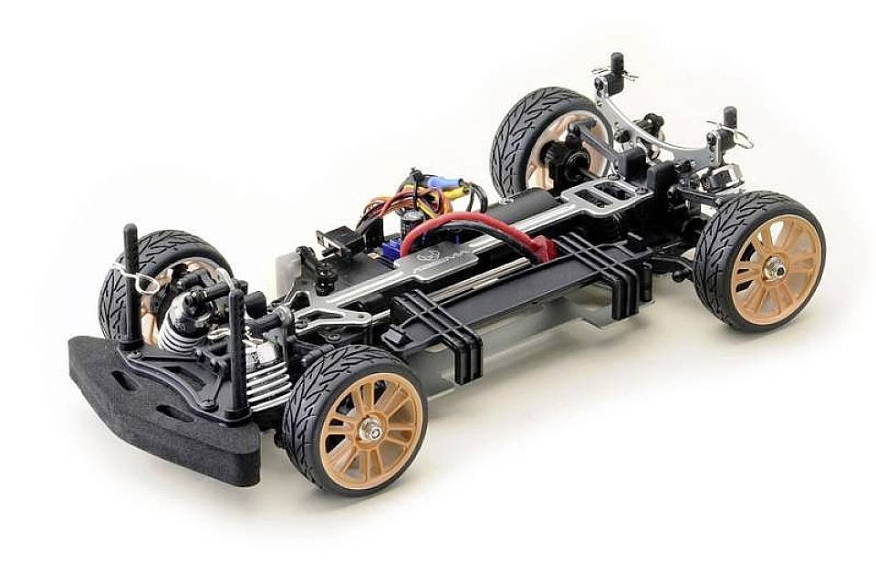 Een open chassis van een bestuurbare auto toont wielen, vering en elektronische componenten op een witte ondergrond.