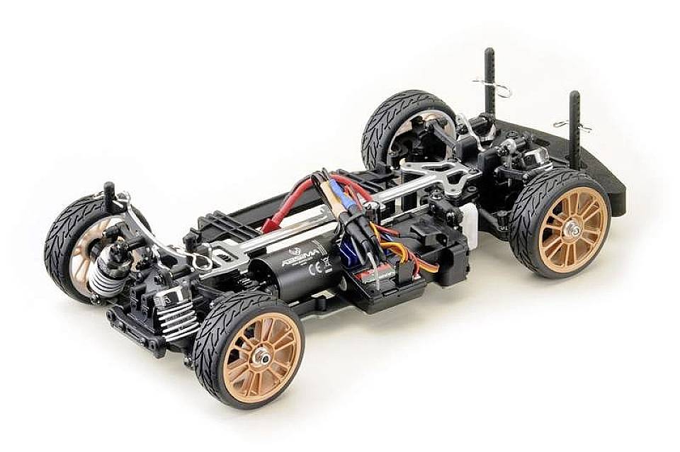 Afstandsbediend modelauto-chassis met zichtbare vering, motor en bekabeling op witte achtergrond.