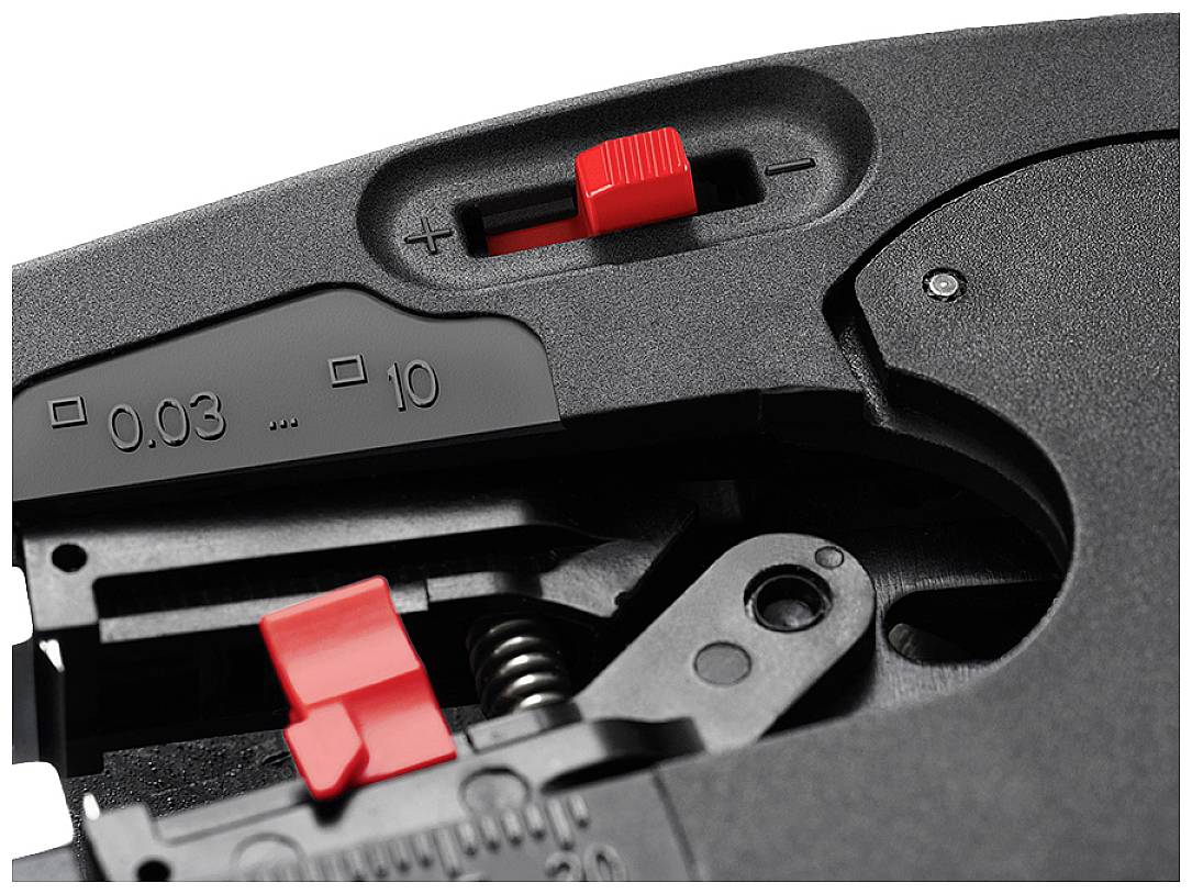 Close-up van een mechanisch apparaat met rode instelknoppen voor nauwkeurige aanpassingen. Schaal zichtbaar van 0,03 tot 10.