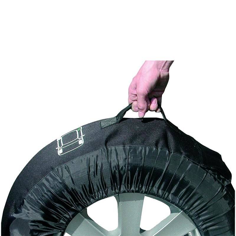 Een hand houdt een zwarte wielafdekking vast met een band, waarop een handelskist is afgebeeld.