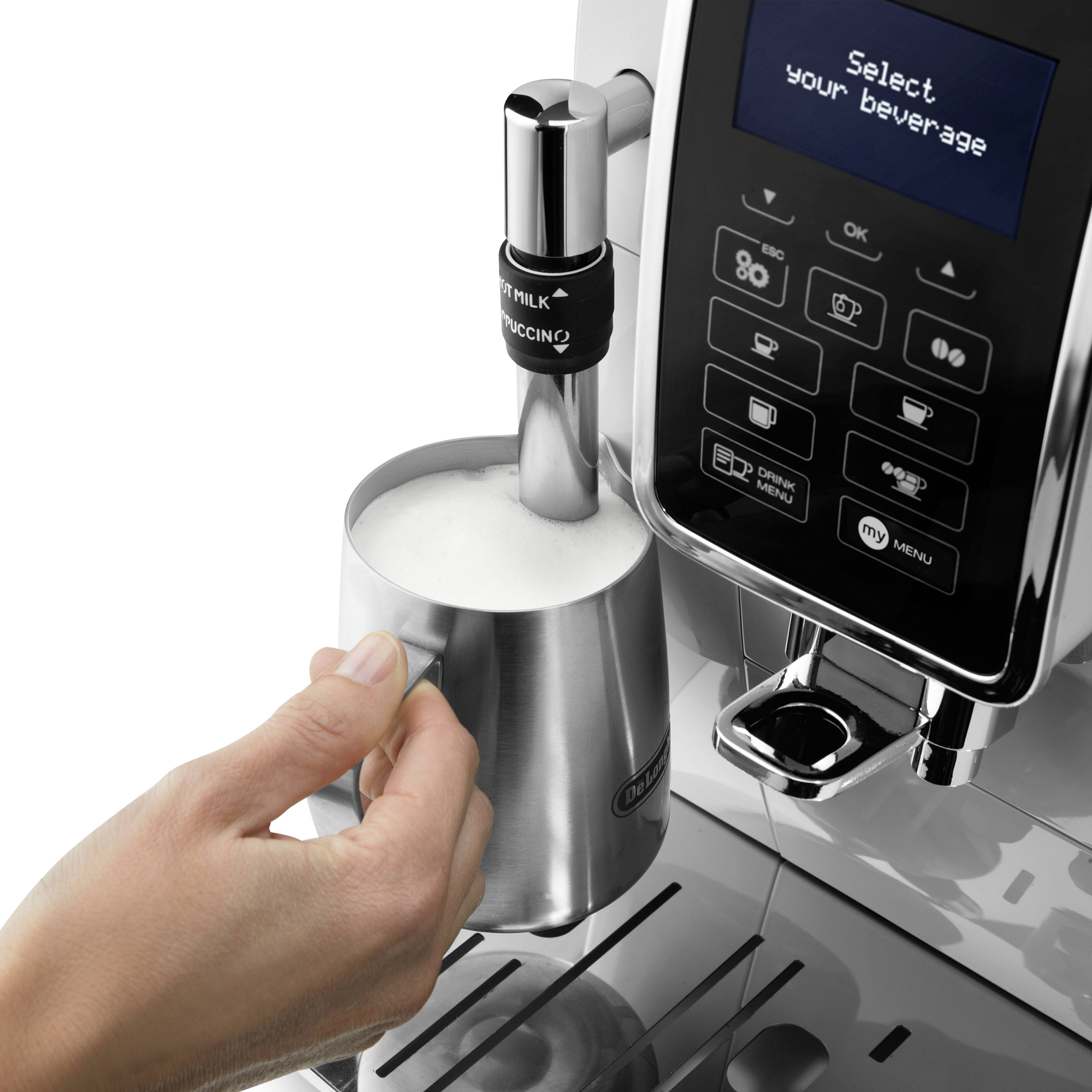 Een hand houdt een melkkan onder een stoomuitloop van een koffiemachine terwijl melk wordt opgeschuimd. Display toont 'Selecteer uw drank'.