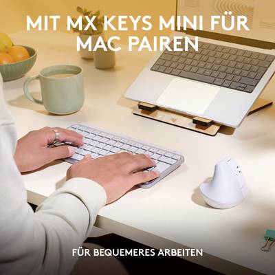 Persoon werkt aan een bureau met een MX Keys Mini-toetsenbord en laptop. Tekst: 'Met MX Keys Mini voor comfortabeler werken'.