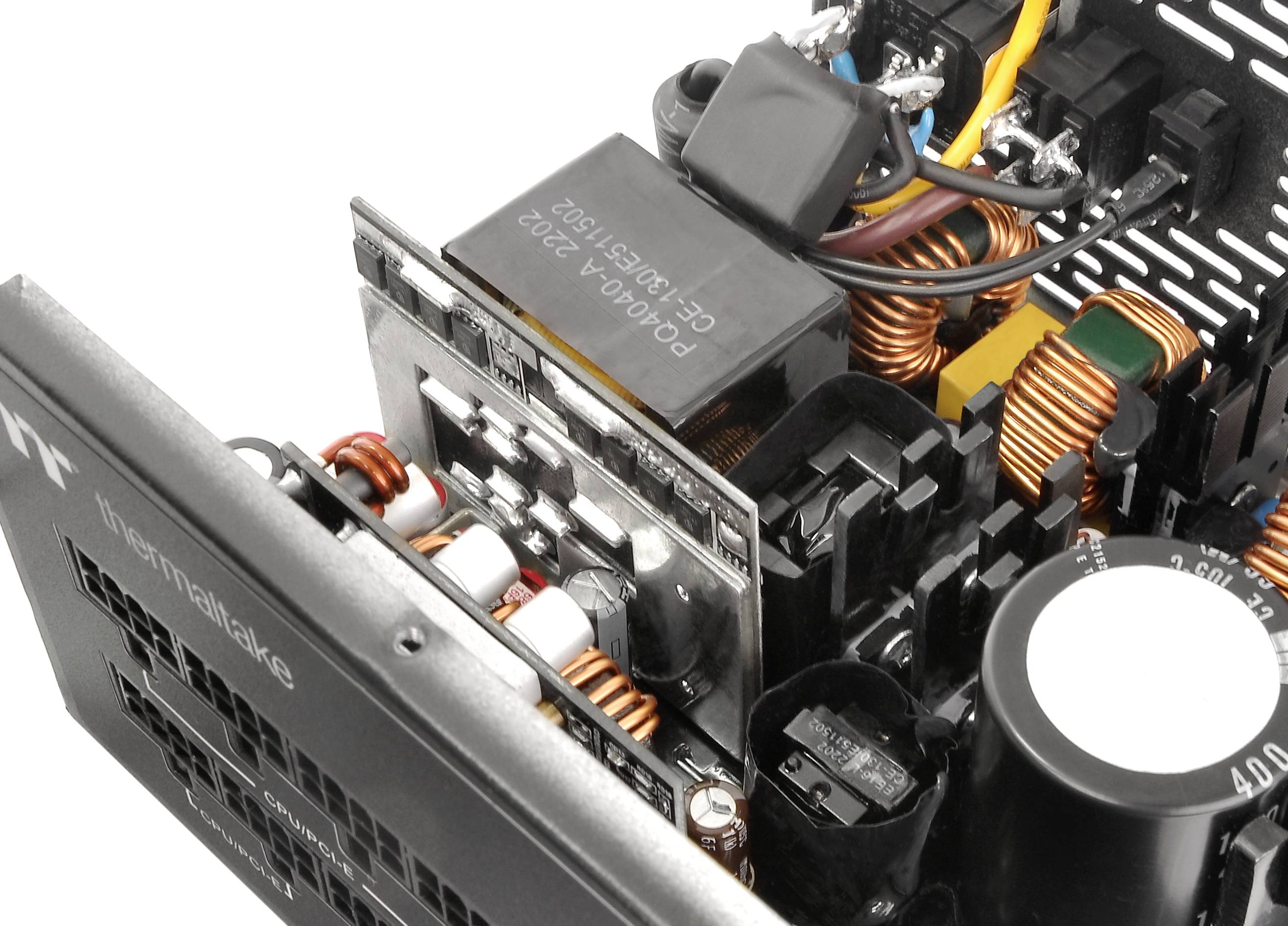 Een geopende computervoeding toont spoelen, condensatoren en kabelverbindingen. Zichtbaar opschrift: 'InnoSwitch'.