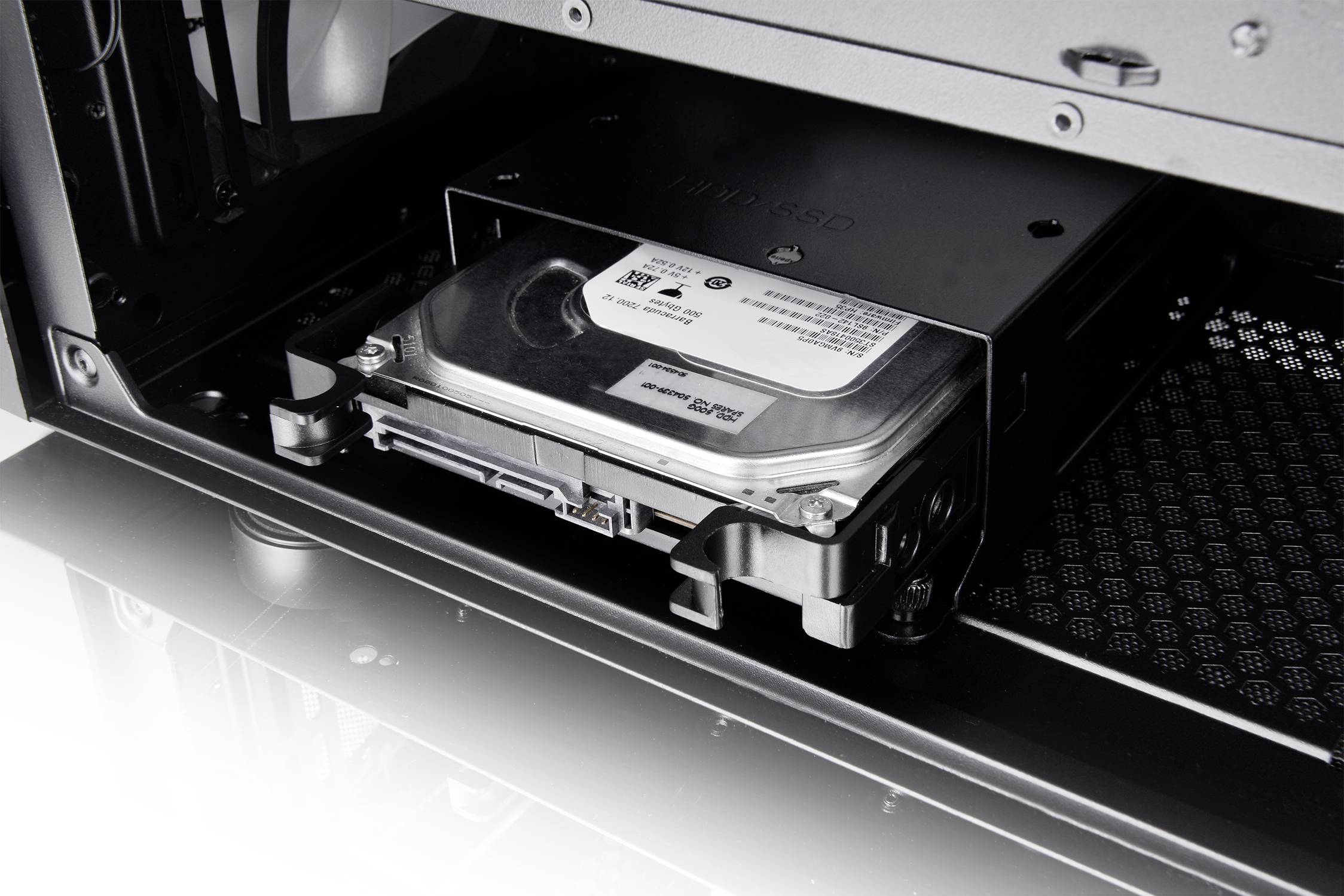 Een computerbehuizing met een geopende voorkant toont een ingebouwde harde schijf in een stationssleuf.