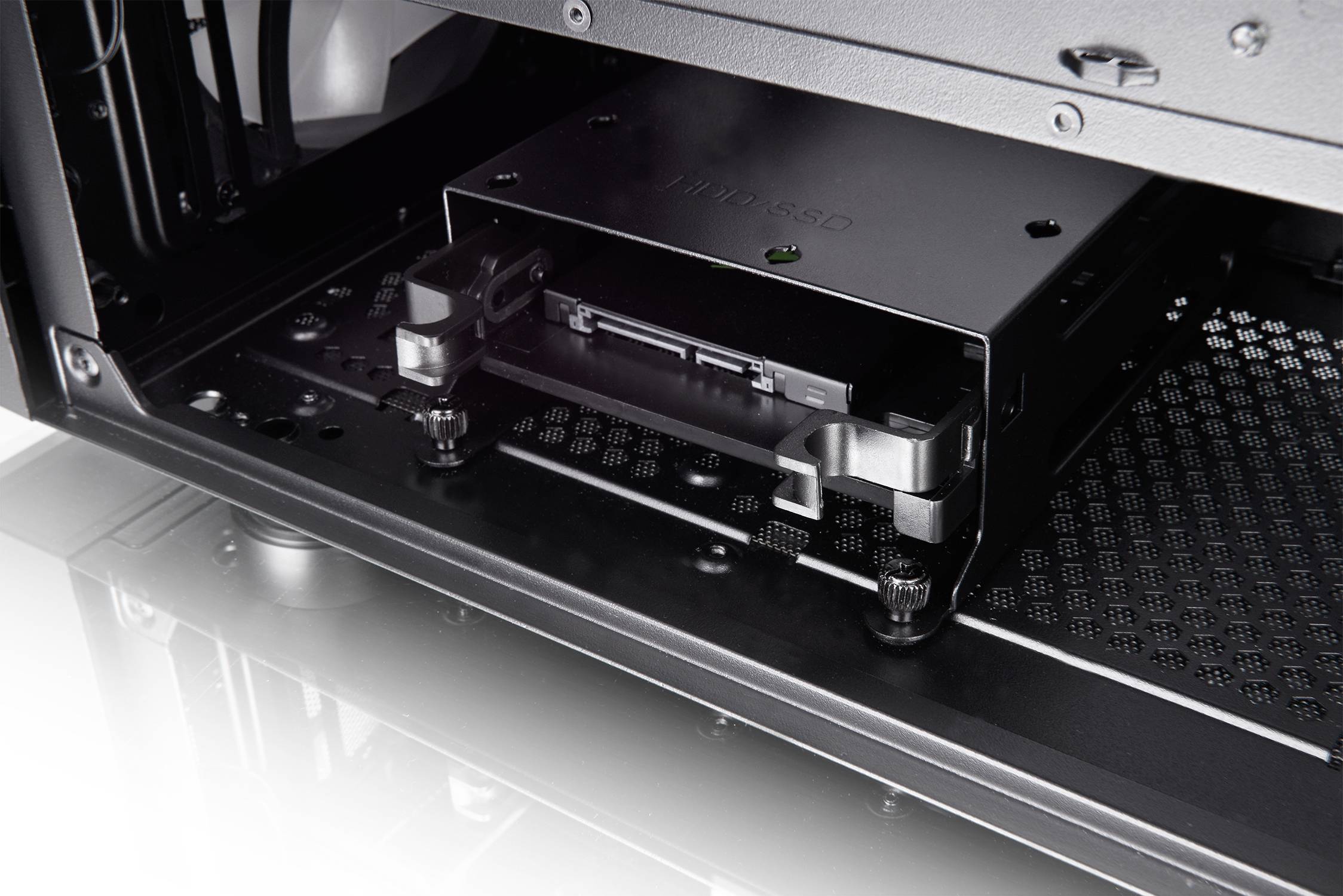 Close-up van een computerbehuizing met een geïnstalleerde schacht voor apparaten, waarin een opslagapparaat is geplaatst. Kabels en bevestigingen zijn zichtbaar.