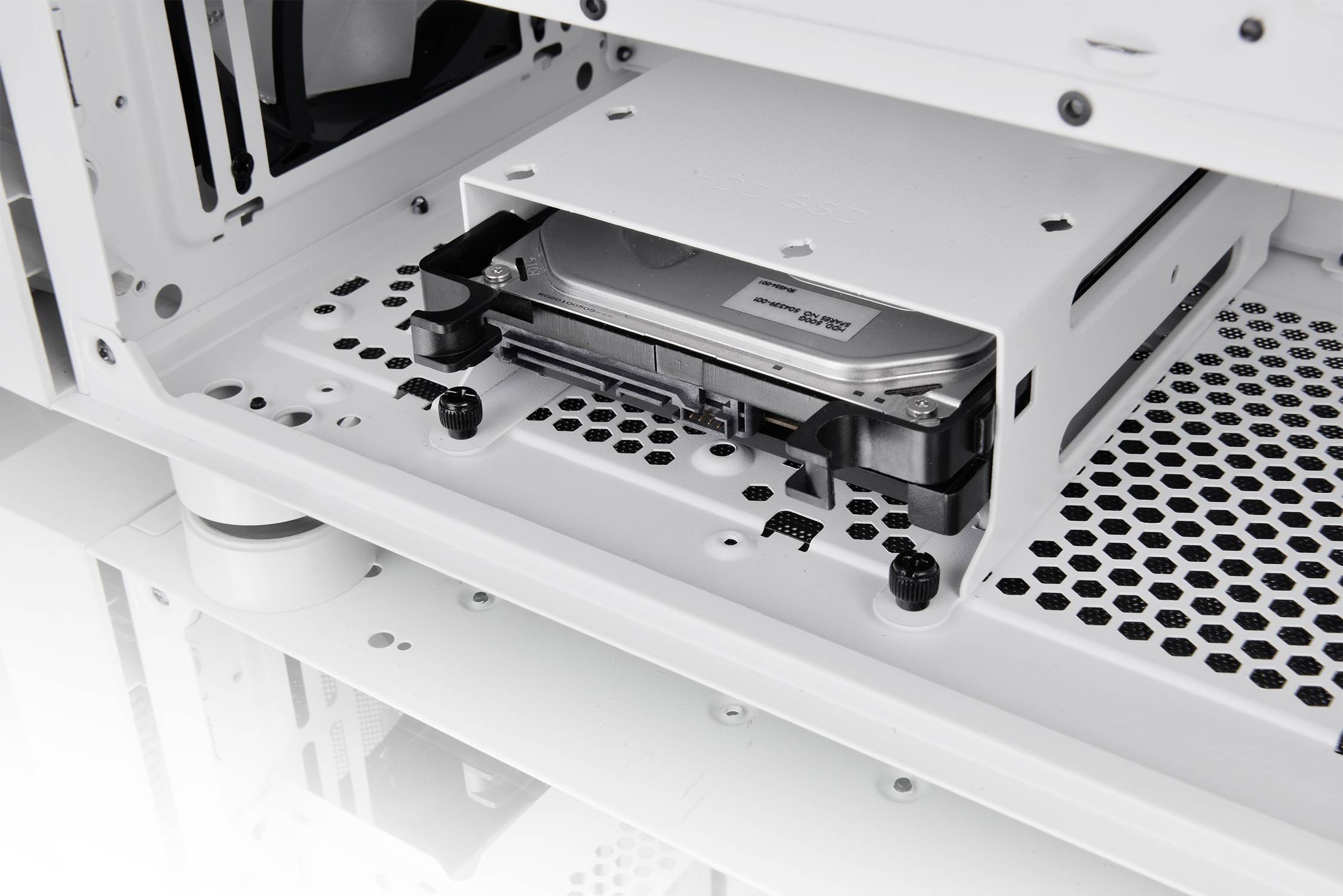 Een computerbehuizing toont een ingebouwde harde schijf in een sleuf, omgeven door ventilatiesleuven en kabelopeningen.