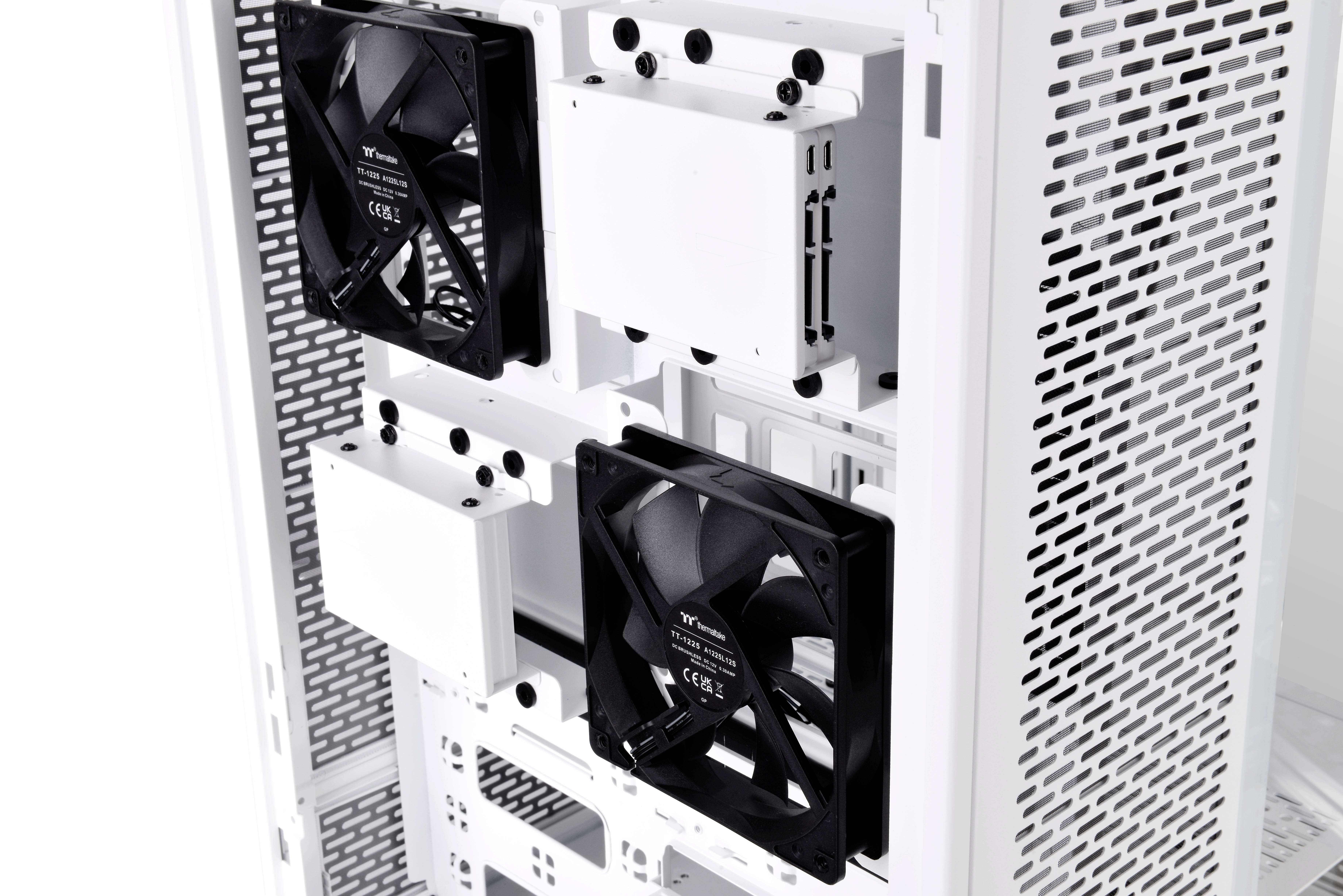 Wit computerbehuizing met zwarte ventilator binnenin zichtbaar. Ventilatoren zijn gemonteerd aan de rechterzijde, behuizingsrooster links zichtbaar.