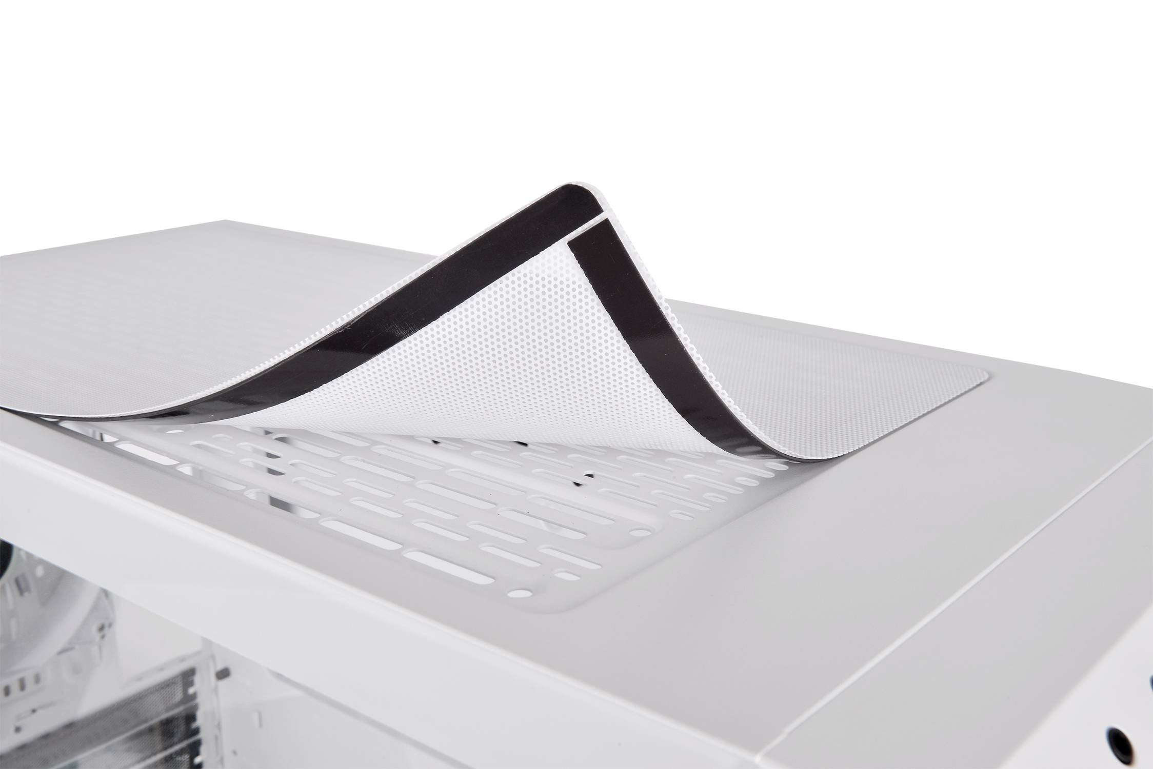 Een wit computerbehuizing met een verwijderbare, zwarte ventilatorafdekking bovenaan, toont de ventilatiesleuven daaronder.