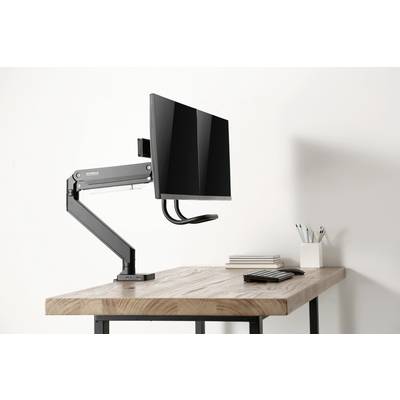 Het bureau toont een moderne, verstelbare monitorarm met een gemonteerd beeldscherm. Ernaast liggen pennen, notitieboeken en een rekenmachine.