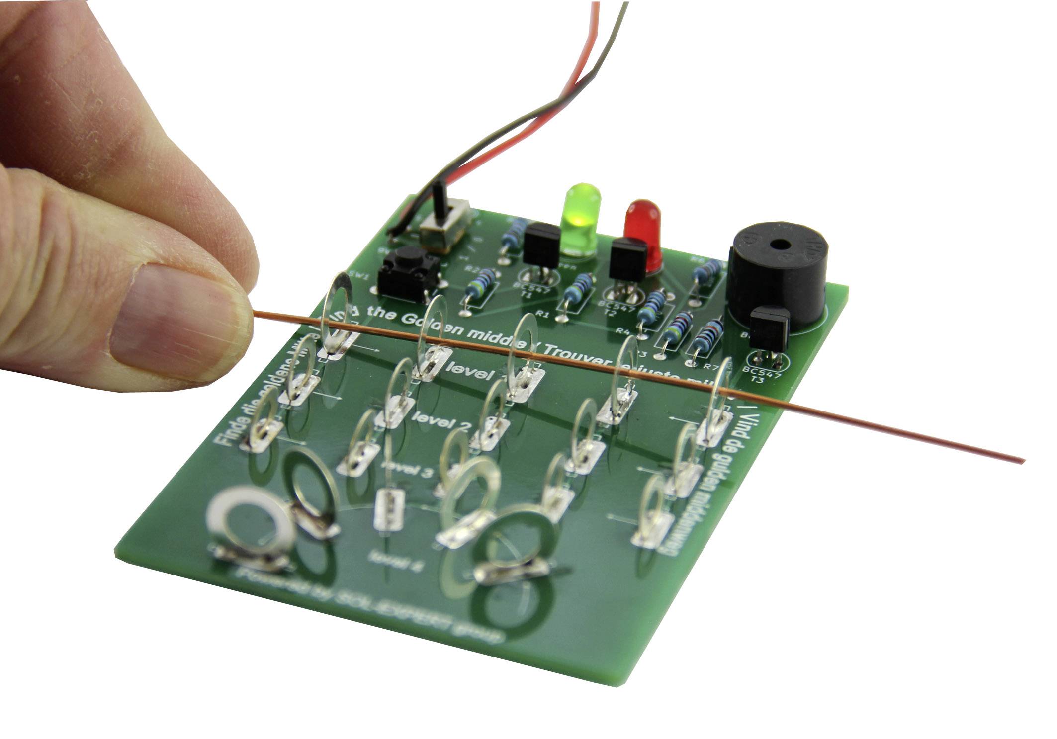 Een hand houdt een draad voor een groene printplaat met verschillende elektronische componenten zoals led's en weerstanden.