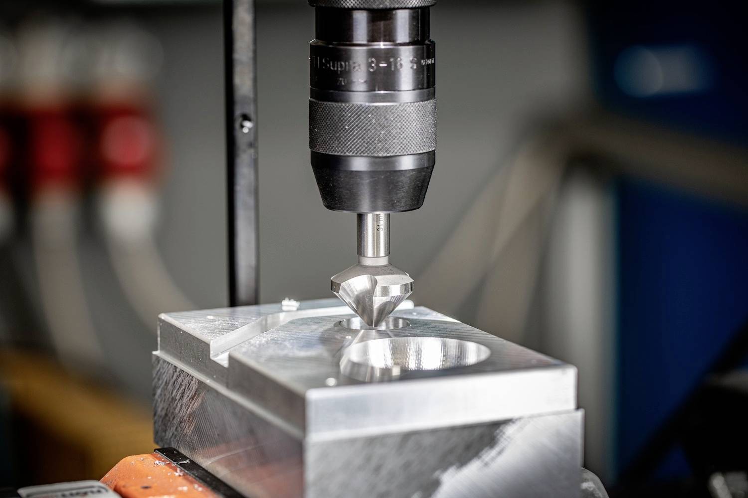 Een freesmachine bewerkt een metalen onderdeel, waarbij de frees boven een rechthoekige metalen plaat met een ronde uitsparing zweeft.