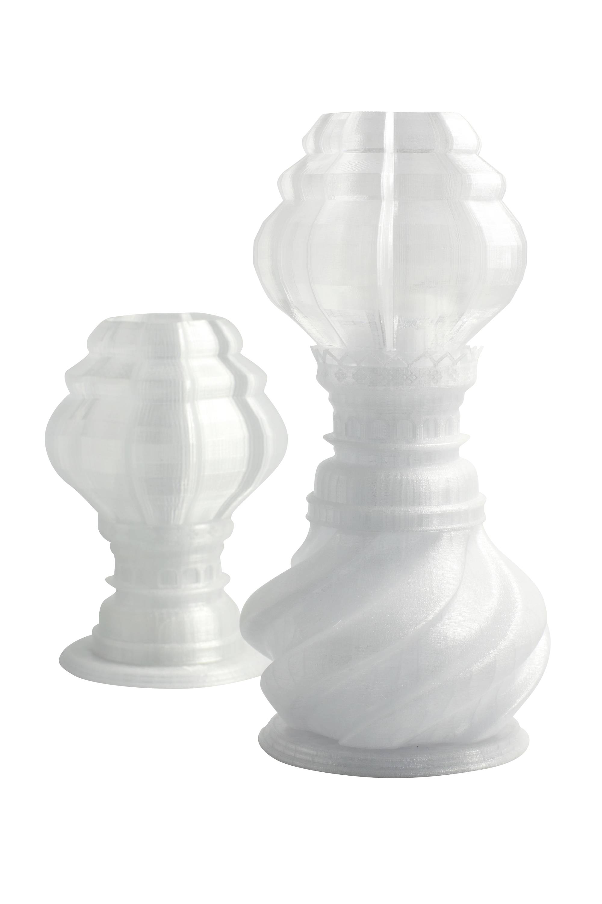 Twee decoratieve, gedraaide glazen kolven in verschillende formaten, transparant en witachtig, tegen een witte achtergrond.