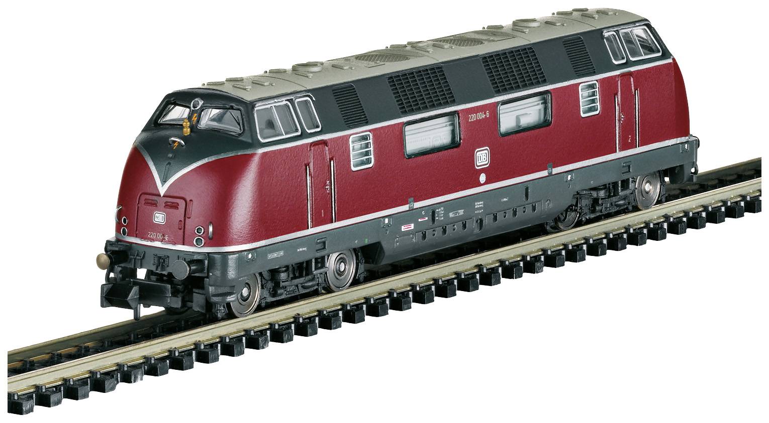 Een modeltreintje, rood en zwart, rijdt op rails. Het model toont een locomotief met authentieke details en opschriften.