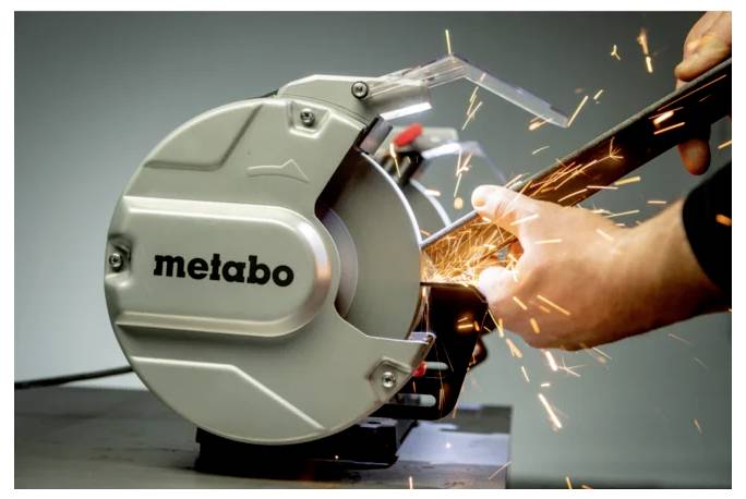 Een persoon gebruikt een Metabo cirkelzaag om metaal te snijden, waarbij heldere vonken ontstaan. De focus van de zaag benadrukt precisie en industrieel gebruik.