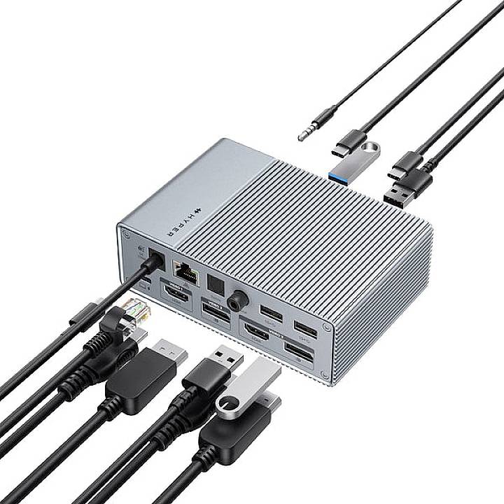 Zilveren dockingstation met meerdere aansluitingen: USB, HDMI, Ethernet. Verschillende kabels zijn aangesloten, aangevuld met losse stekkers.