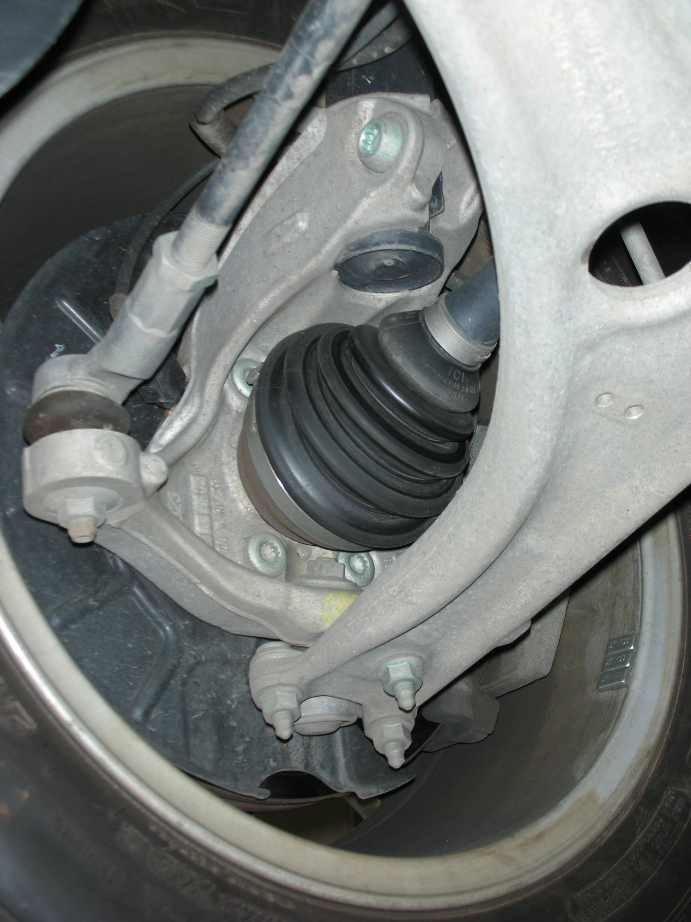 Close-up van een auto-ophanging. De aslaarzen en delen van de wielnaaf zijn zichtbaar. Essentie van de voertuigmechanica.