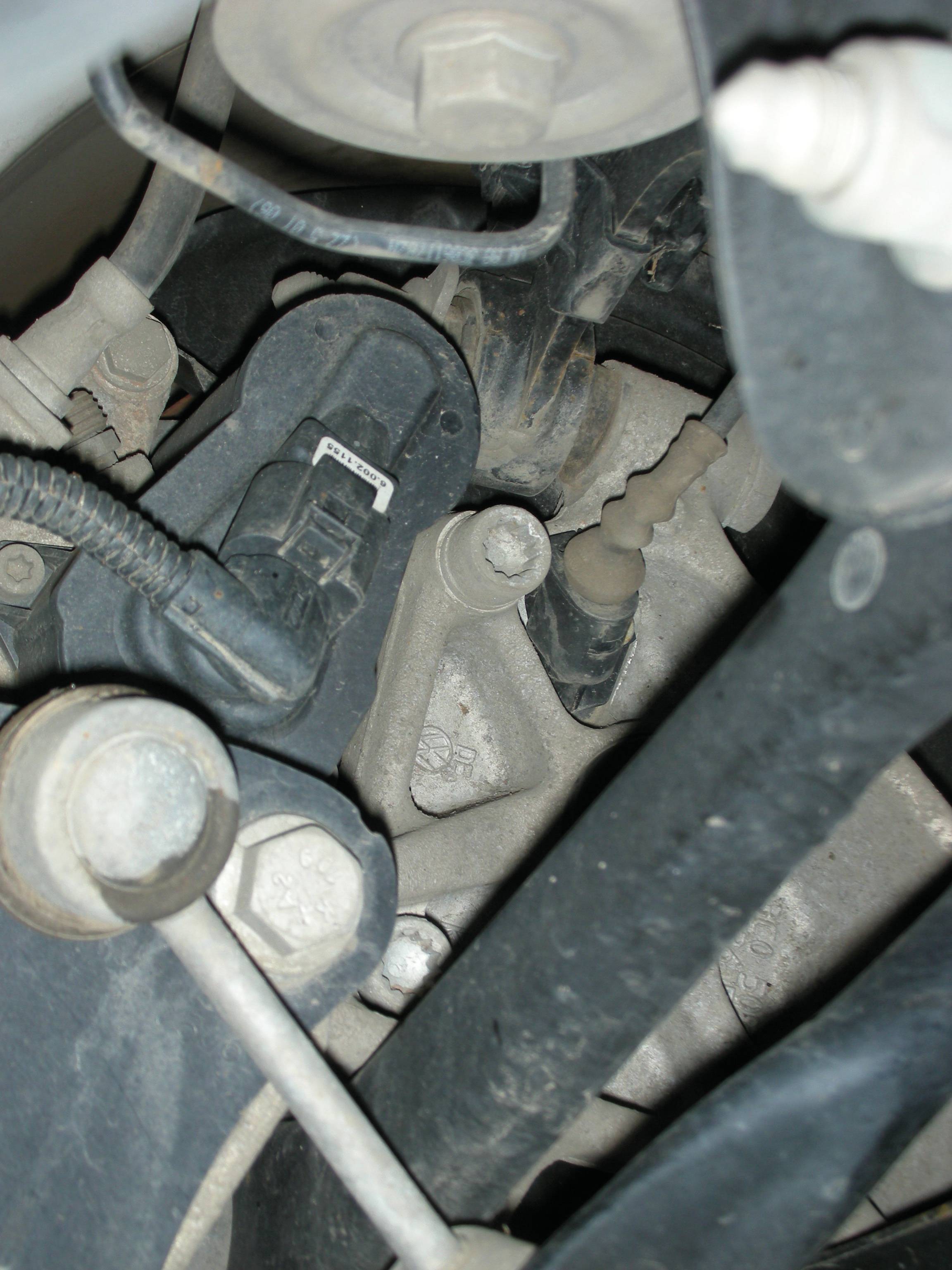 Een blik op een voertuigonderstel met schokdempers, bouten en kabels, onthult details van de automechanica van onderaf.