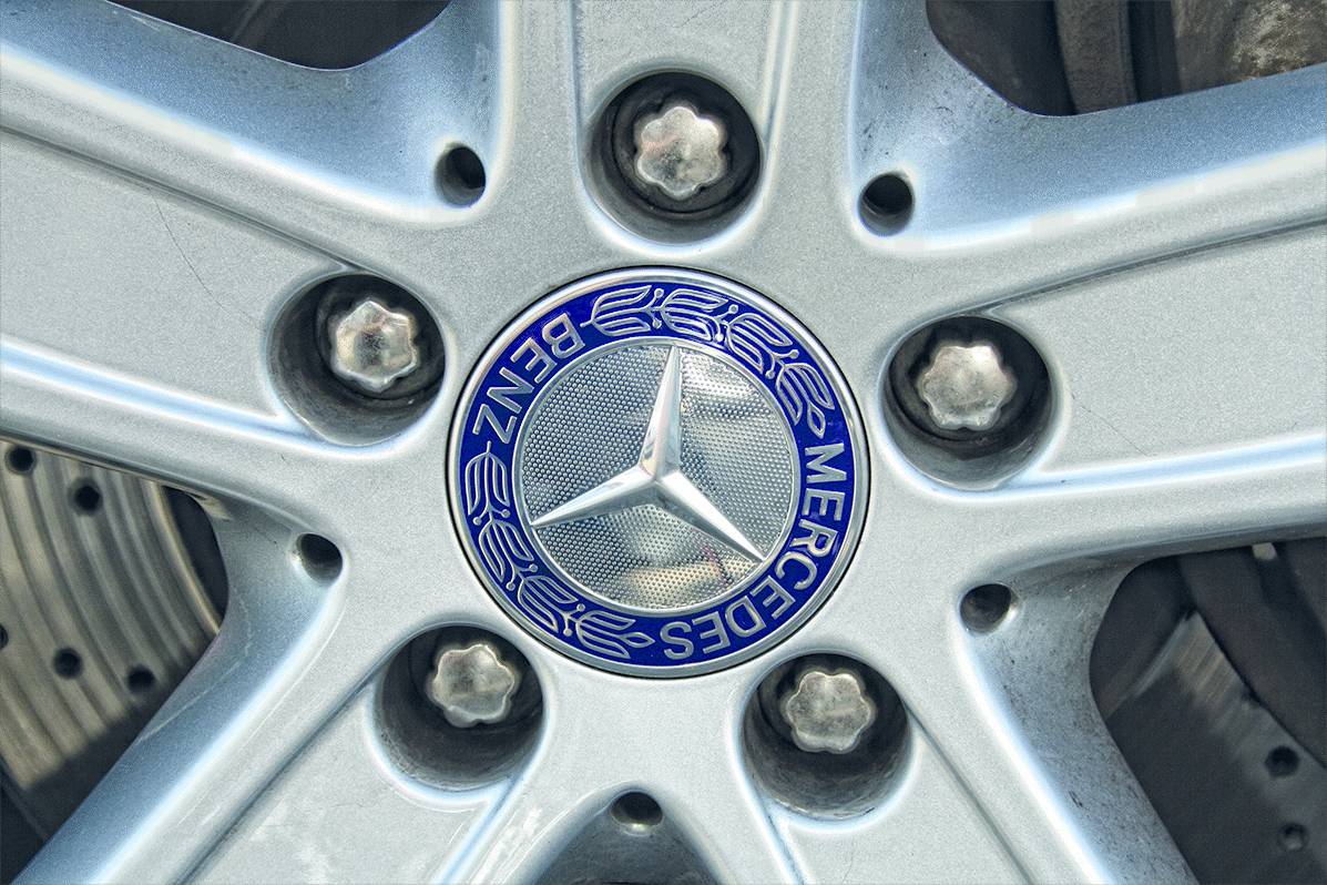 Autoband met een Mercedes-Benz-velg. In het midden bevindt zich het Mercedes-logo, omringd door vijf wielmoeren.