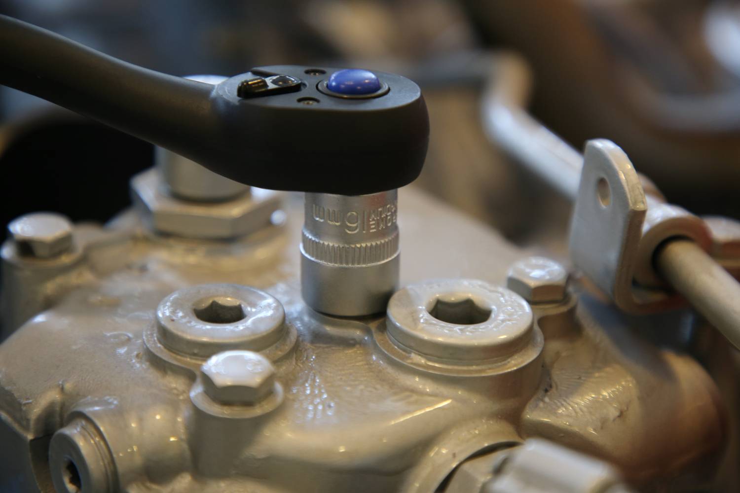 Een moersleutel draait een schroefverbinding aan op een metalen machine. Close-up van het werkproces.