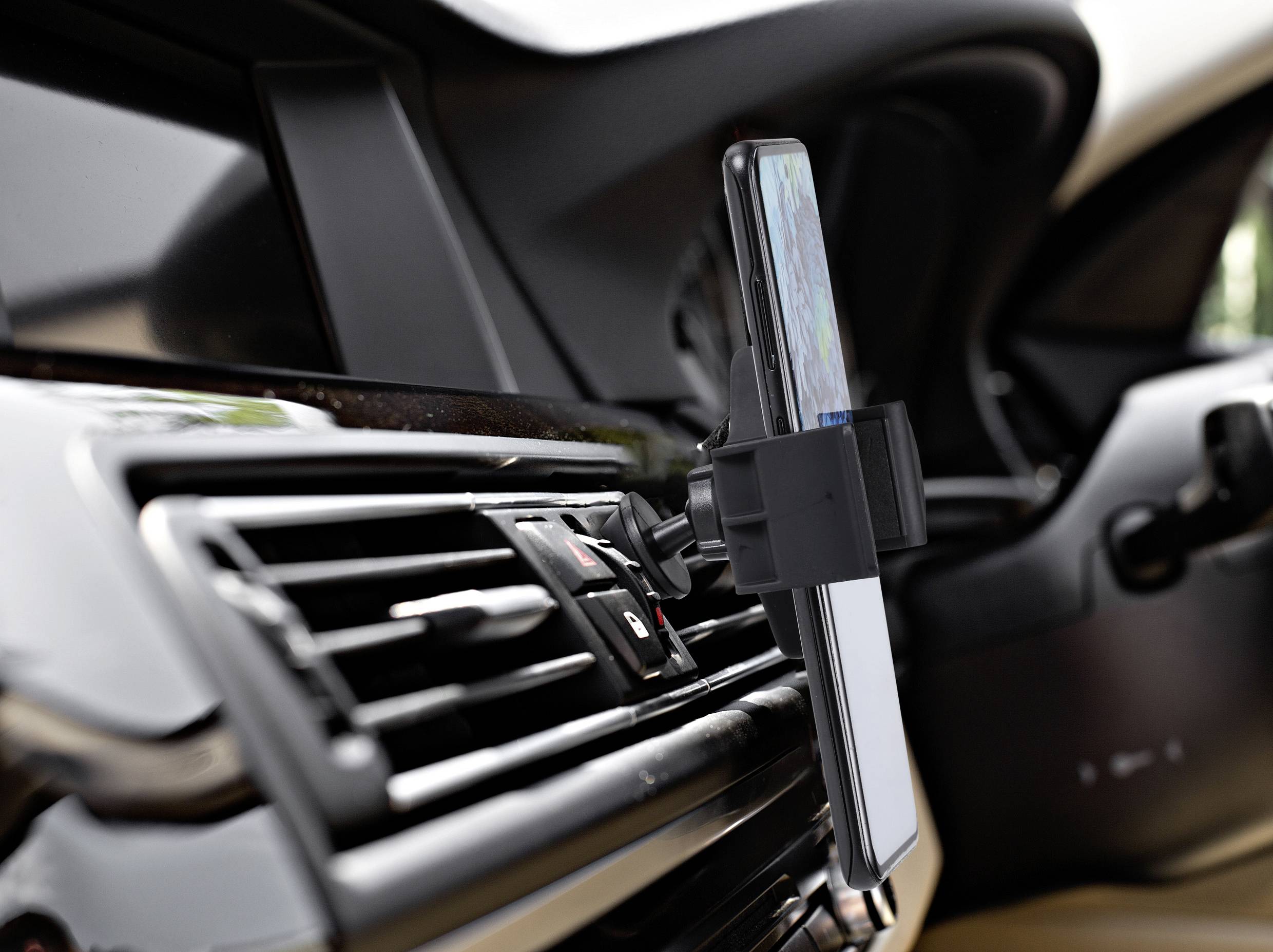 Telefoonhouder in de auto, bevestigd aan de ventilatierooster, houdt smartphone met navigatie-app zichtbaar. Bestuurdersvriendelijk ontwerp voor navigatie.