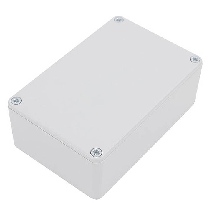 Een rechthoekige, grijze kunststof doos met vier zichtbare schroeven op de hoeken, waarschijnlijk een behuizing voor elektronische componenten.