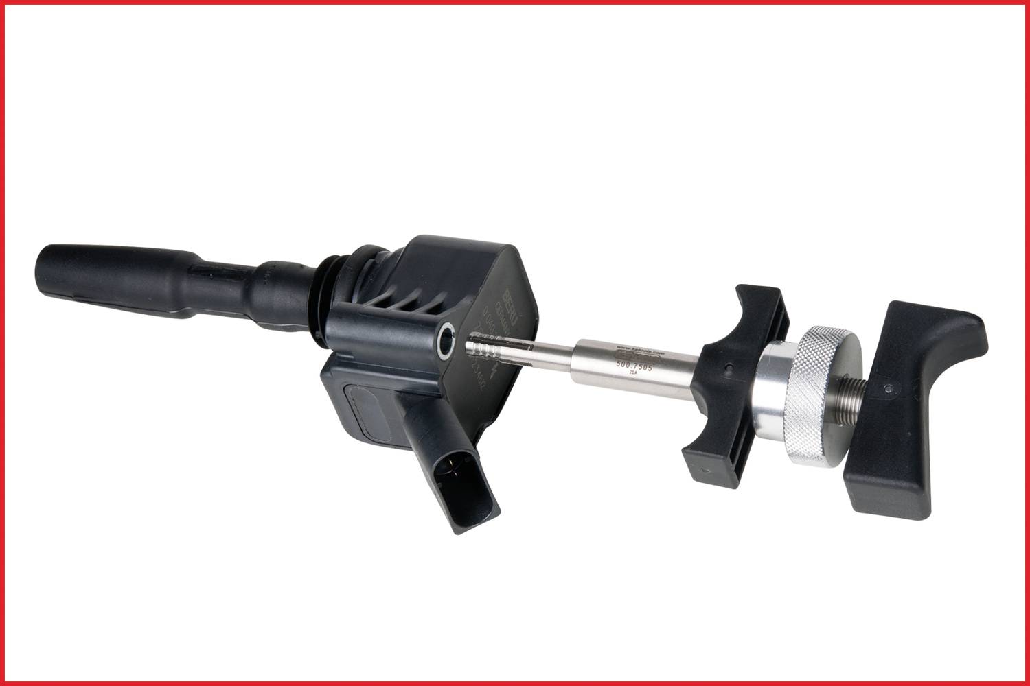 Een zwart bobine-gereedschap met metalen onderdeel en twee handgrepen, dat wordt gebruikt voor reparatie of montage van auto-ontstekingssystemen.