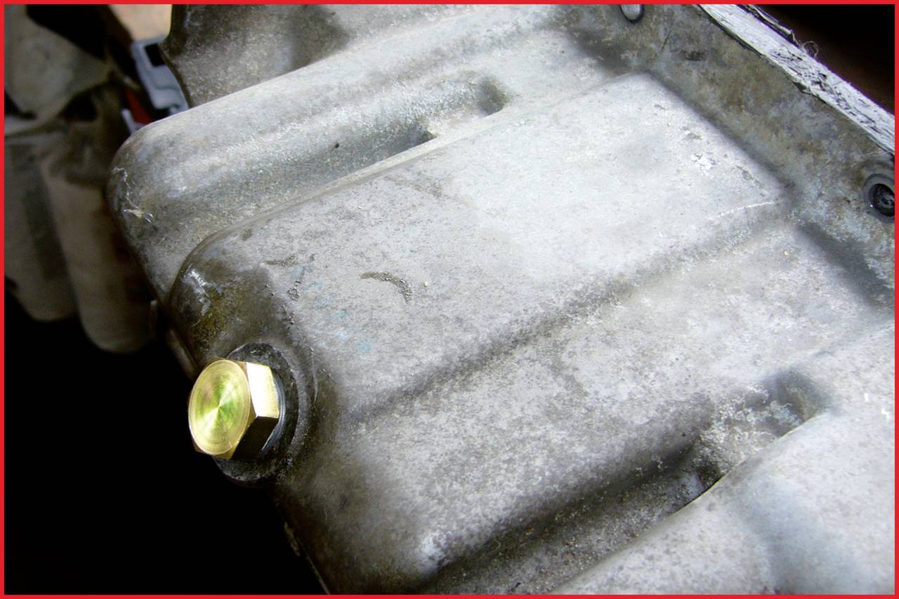 Een roestige metalen motorblok met een gouden schroefkop.