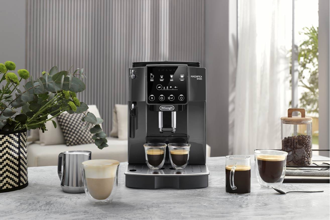 Een koffiemachine op een tafel in een moderne keuken. Drie glazen met verschillende soorten koffie staan voor de machine.