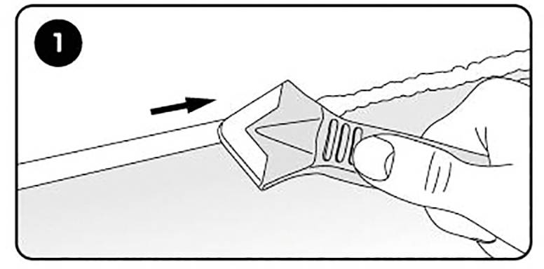 Een hand houdt een gereedschap vast en schraapt een strook van een oppervlak.