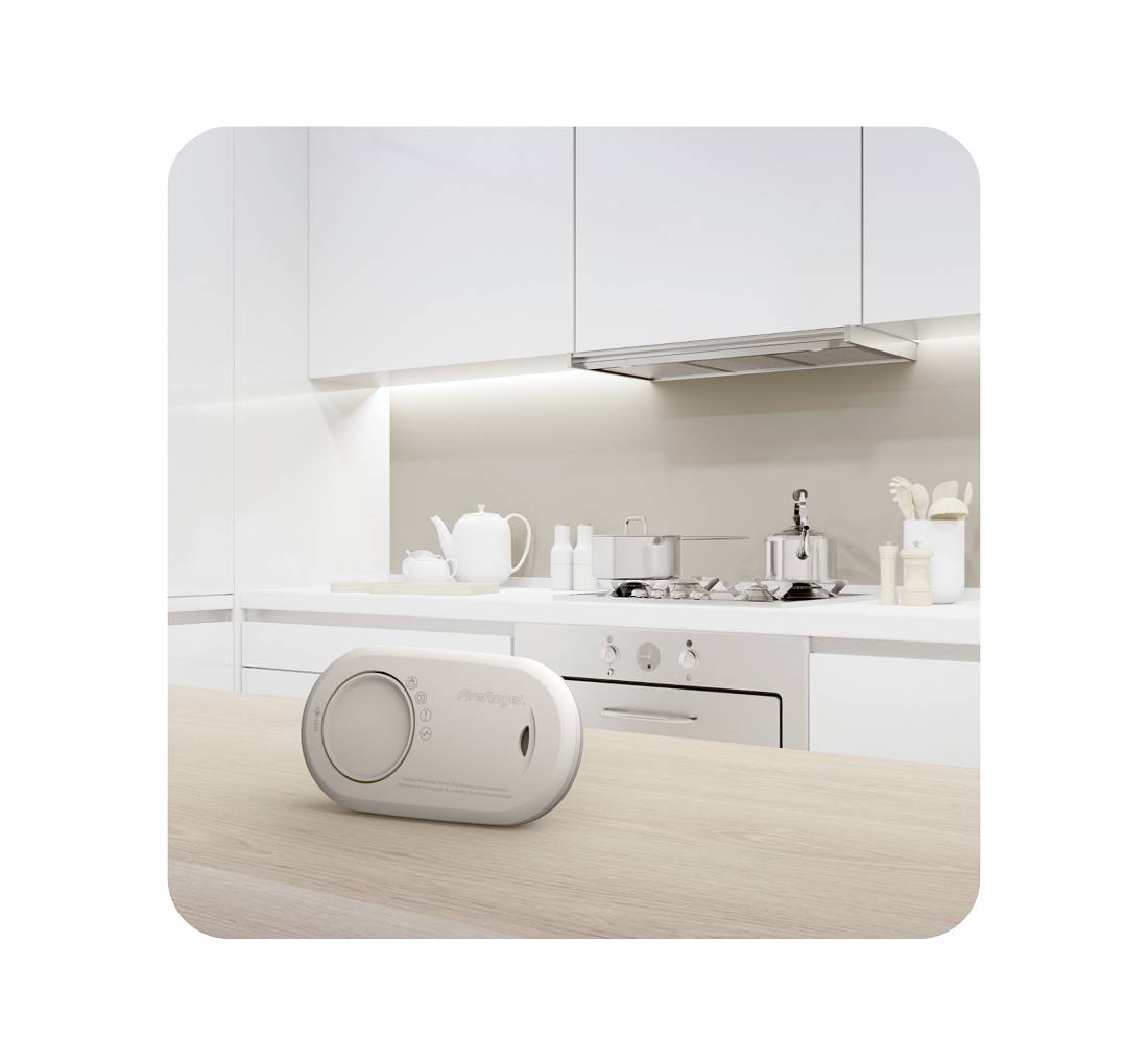 Keukentafereel met een witte waterkoker en kookgerei op het aanrecht, waarbij zich in de voorgrond een wit, ovaal apparaat met display bevindt.