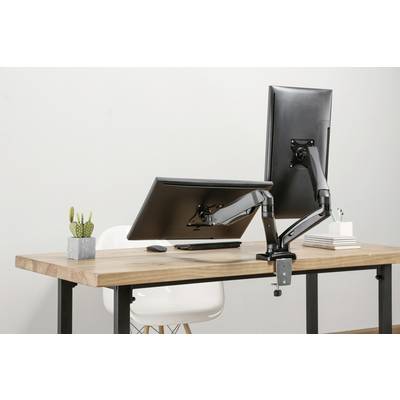 Twee monitoren op verstelbare steunen op een houten tafel; een verticaal, de andere horizontaal. Links een kleine plant.