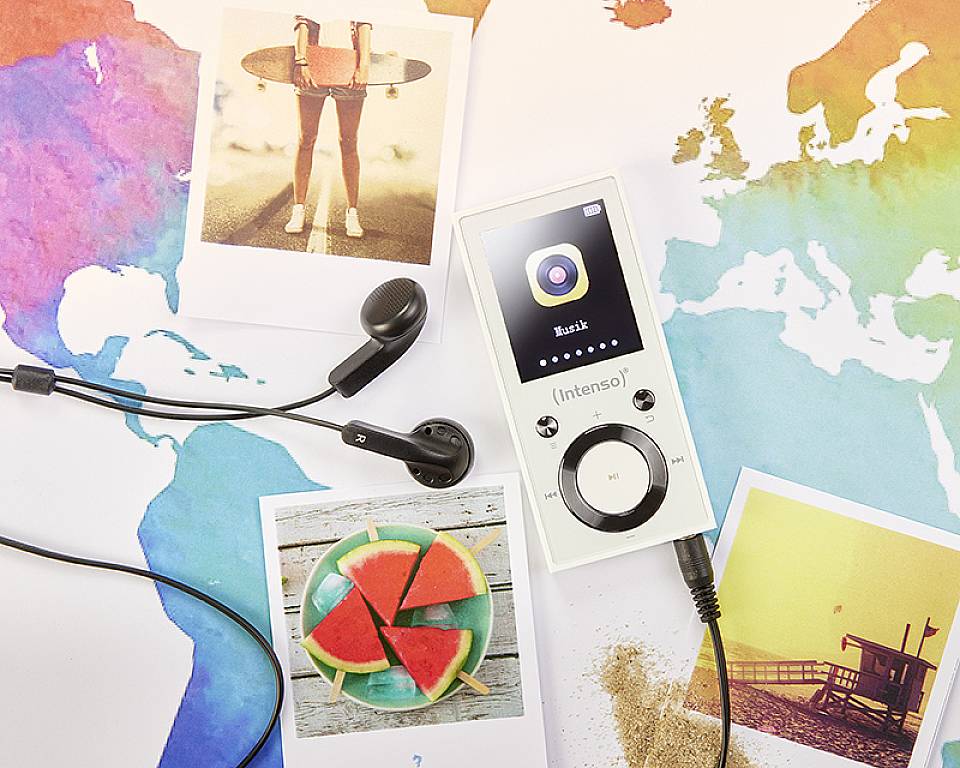 Een draagbare muziekspeler en koptelefoon liggen op een kleurrijke wereldkaartachtergrond. Ernaast liggen Polaroid-foto's met verschillende afbeeldingen.