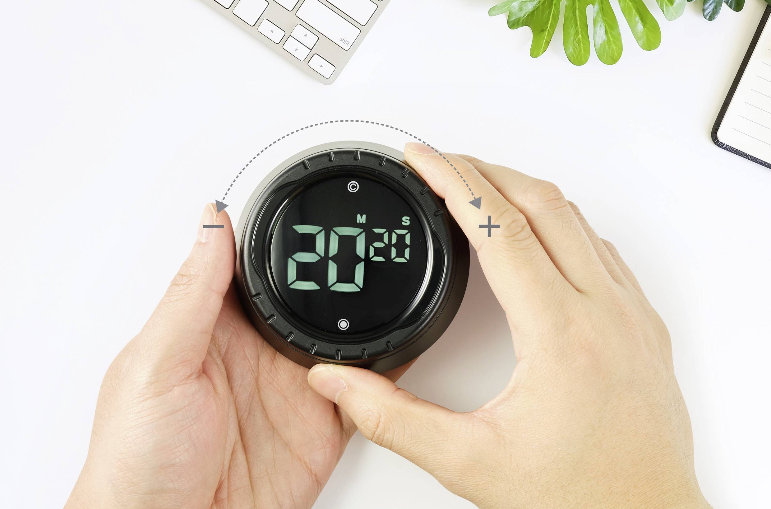 Een persoon stelt een digitale timer in op 20 minuten. De timer heeft een plus- en minteken om de tijd aan te passen.