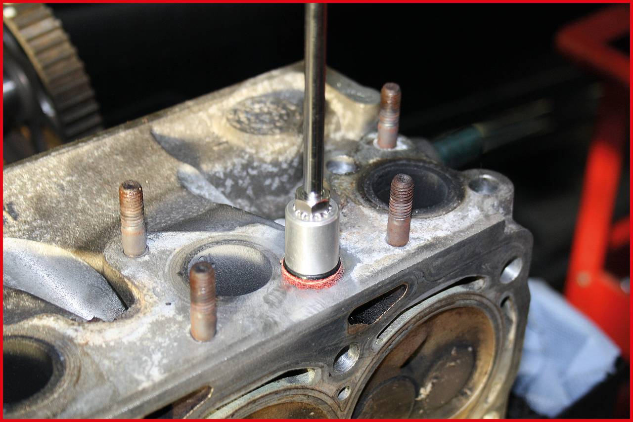 Een close-up van een motorblok waarbij een moersleutel een schroef loshaalt om reparatiewerkzaamheden uit te voeren.
