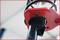 Close-up van een rood metalen onderdeel aan een zwarte staaf, waarschijnlijk deel van een machine of apparaat.