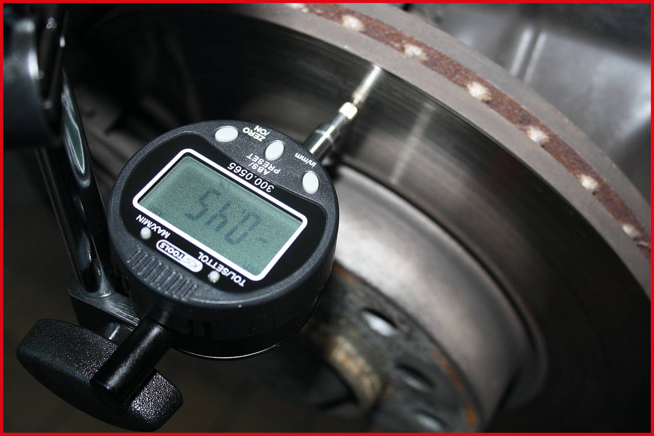 Digitaal meetinstrument meet de remschijfdikte, display toont '5.54' mm. Precisietest voor voertuigveiligheid.