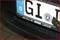 Nederlands nummerbord met EU-embleem en landswapen. Merkenlogo's 'Alfa Romeo', 'Fiat', 'Lancia' onder de kentekenplaat.