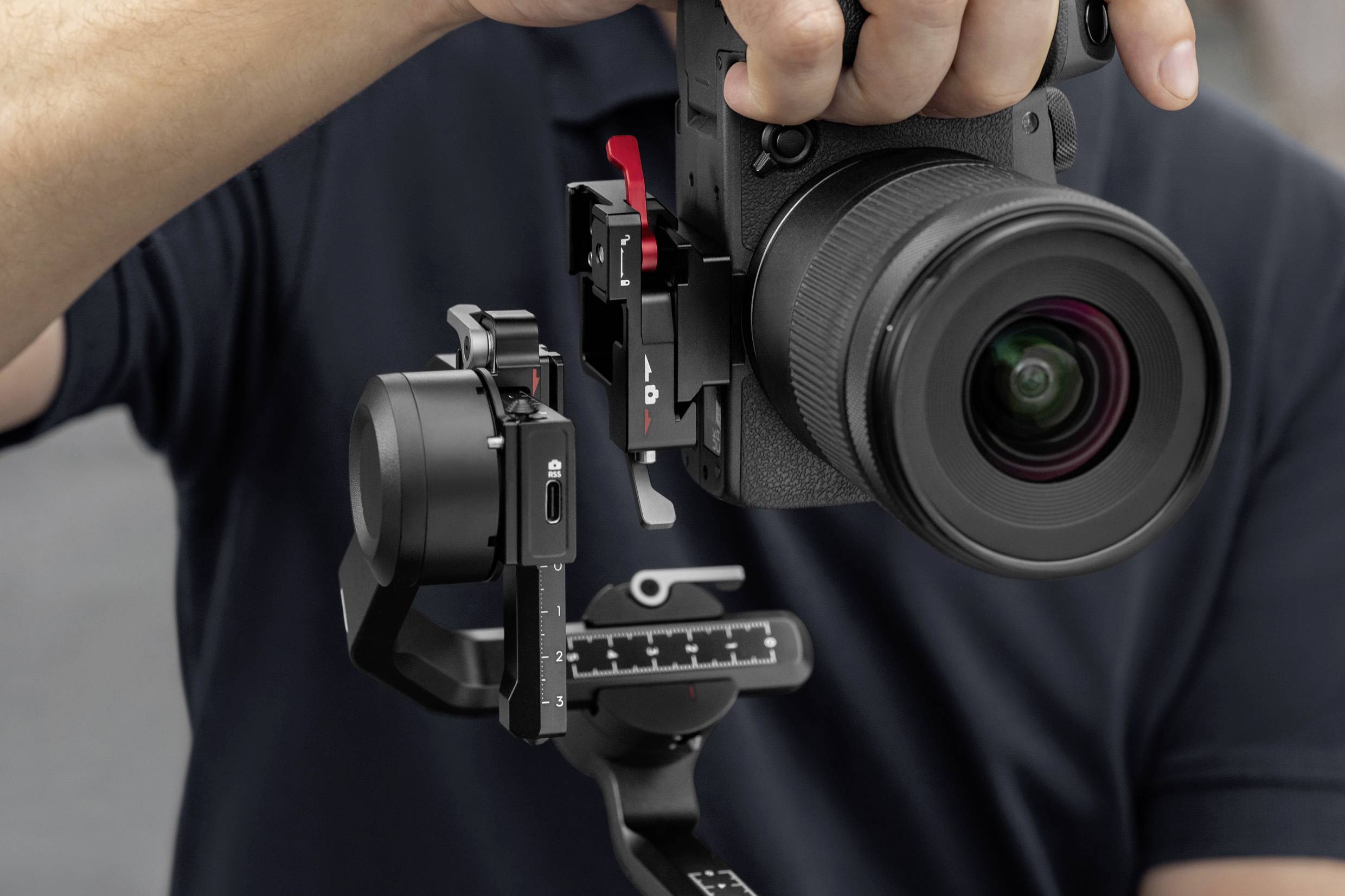Een persoon houdt een professionele camera met een stabiliserende gimbal, die wordt gebruikt voor video-opnamen of fotografie.