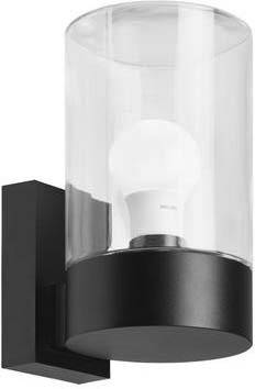 Moderne wandlamp met zwarte voet en heldere glazen cilinder, waarbij een gloeilamp zichtbaar is.