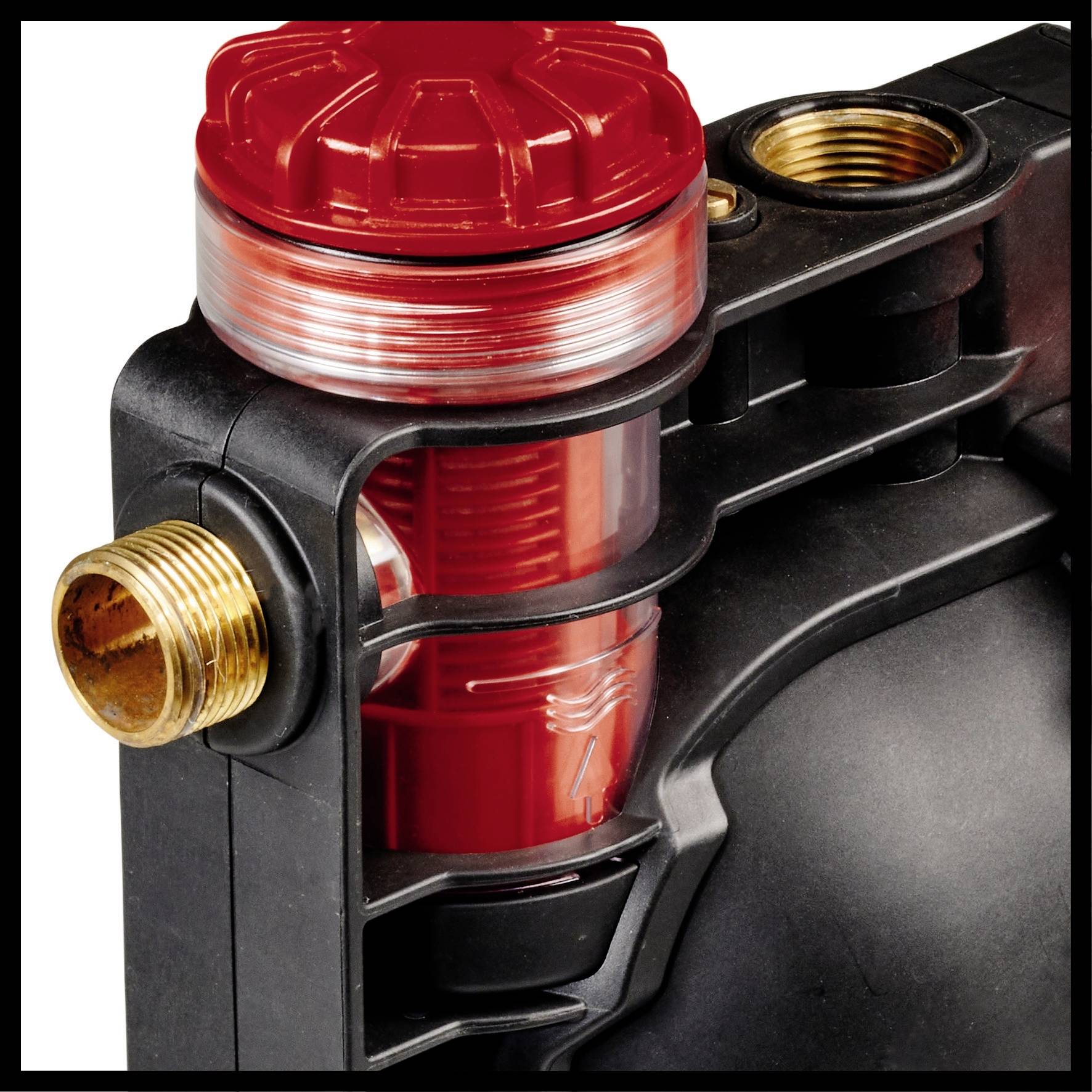 Close-up van een waterfilter met een rood behuizing en zichtbaar filterelement. De filter heeft messing aansluitingen voor de waterleiding.