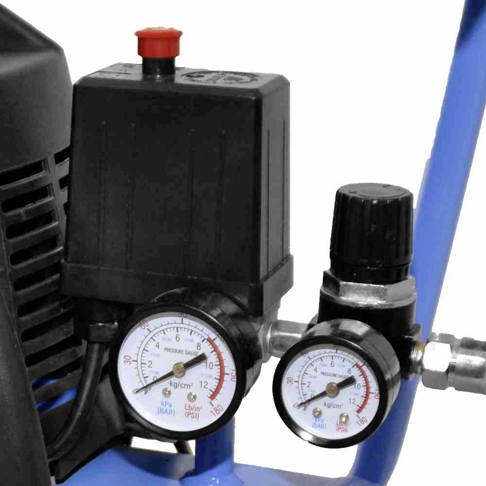 Close-up van twee drukmeteters op een apparaat. De linker toont 12 kg/cm², de rechter 0 kg/cm². Een rode knop is bovenaan zichtbaar.