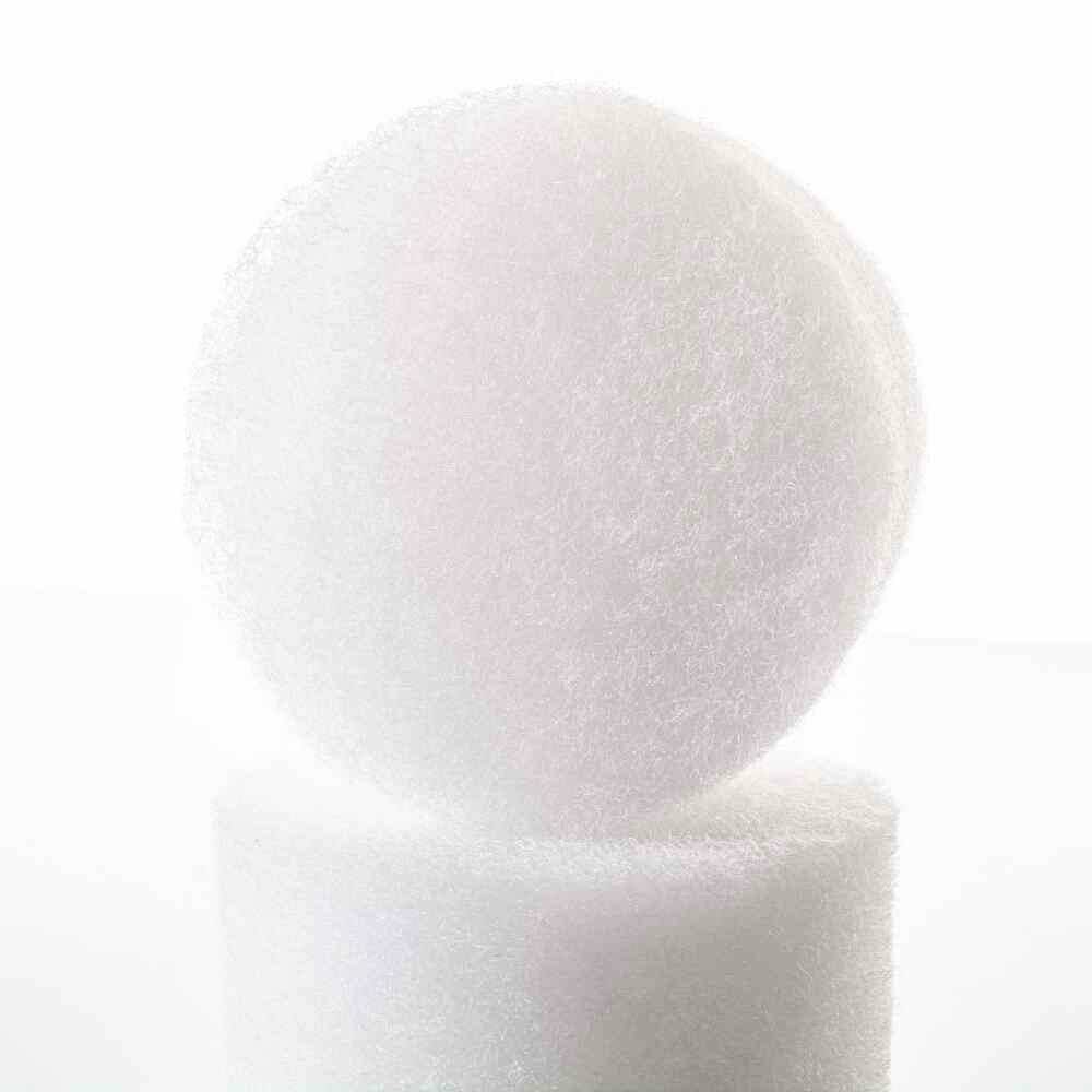 Een witte, ronde spons staat rechtop op een andere spons. Beide hebben een ruwe, poreuze oppervlakte en worden benadrukt door het licht.