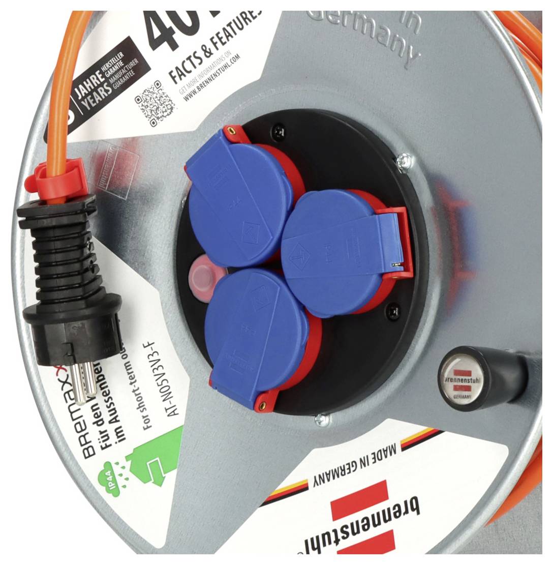 Close-up van een Brennenstuhl kabelspoel met drie blauwe bedekte stopcontacten en een oranje stroomkabel aangesloten.